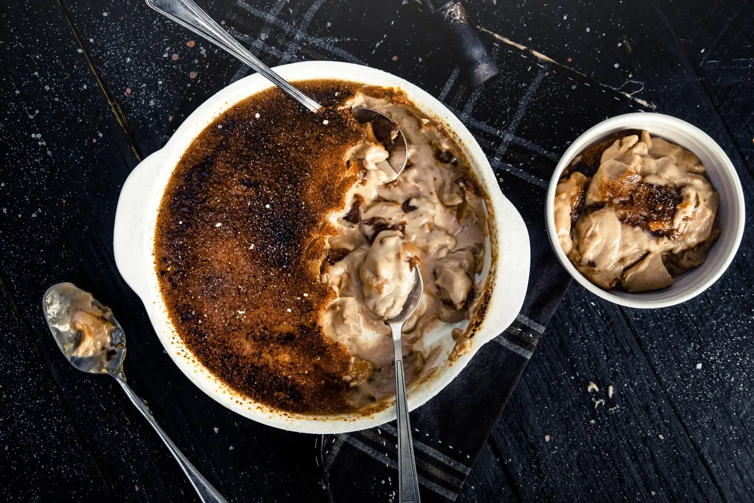 large serving of chai creme brulee tucked in with two serving spoons