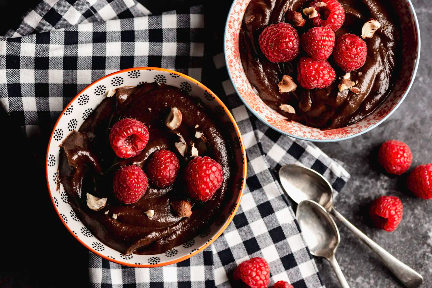 two bowls of creamy vegan chai mousse topped with raspberries