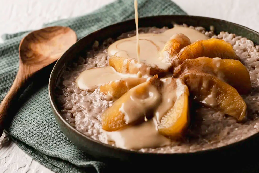 a plat of vegan Chai Rice Pudding with Caramelised Apples drizzled with caramel sauce