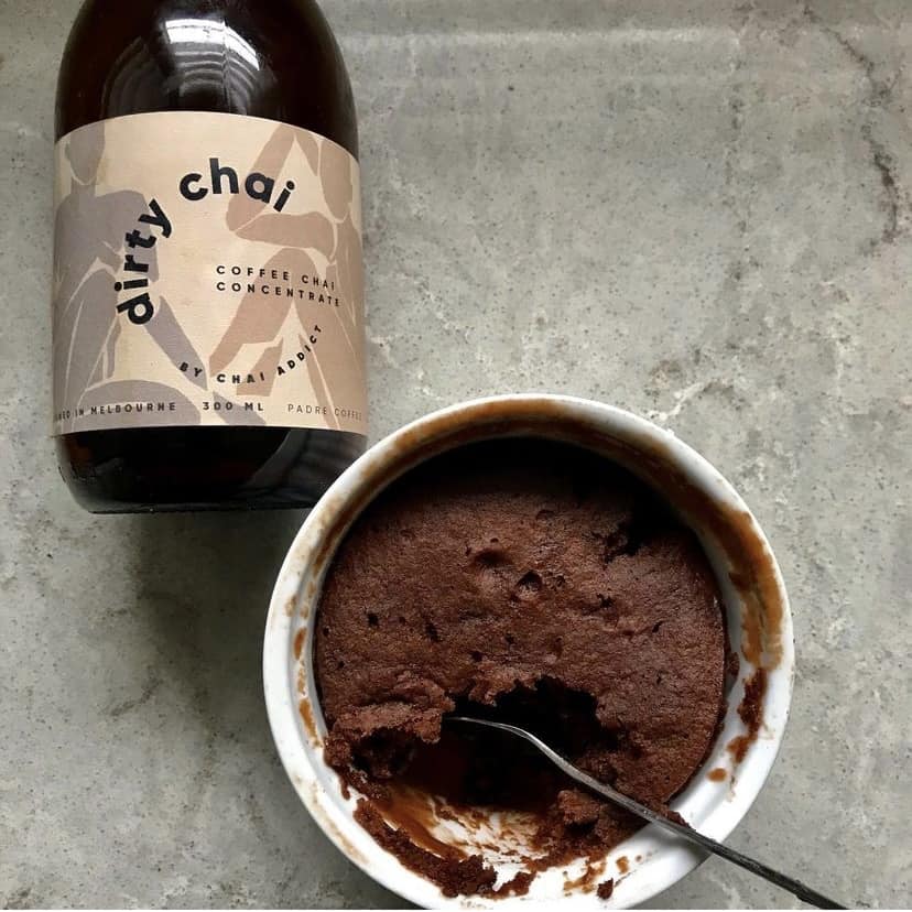 a rameking of Self-Saucing Dirty Chai Chocolate Mug Cake with a bottle of dirty chai concentrate