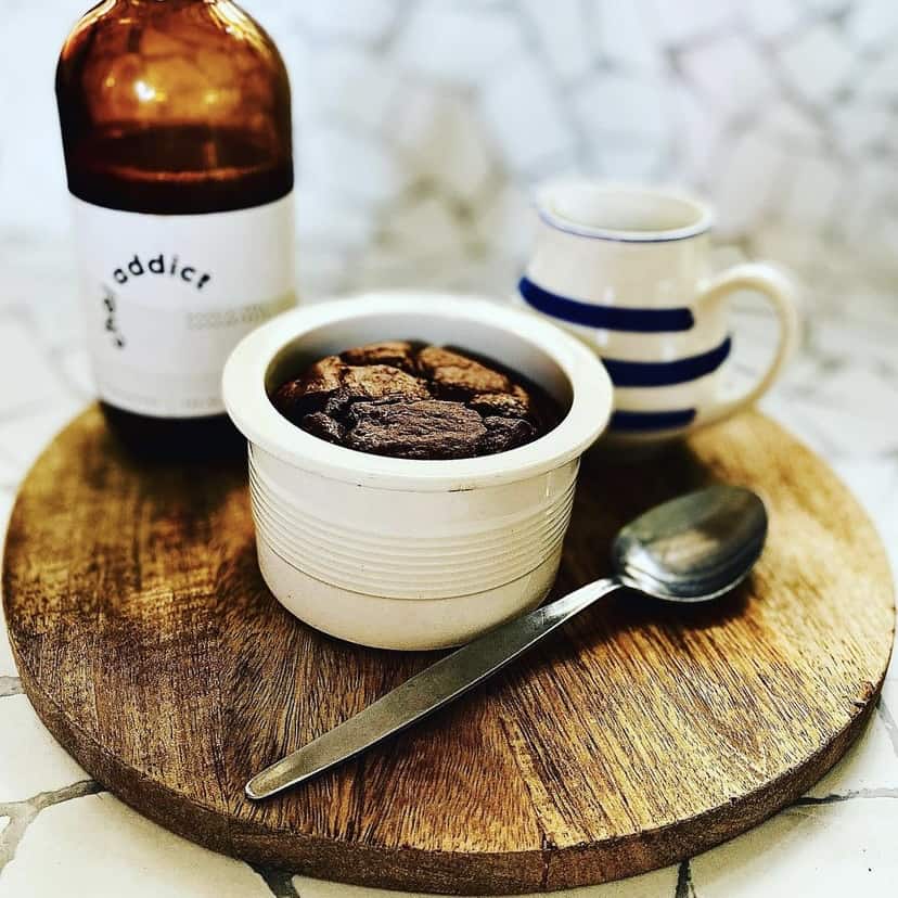 cup of chai, bowl of chai baked oats and a bottle of chai addict