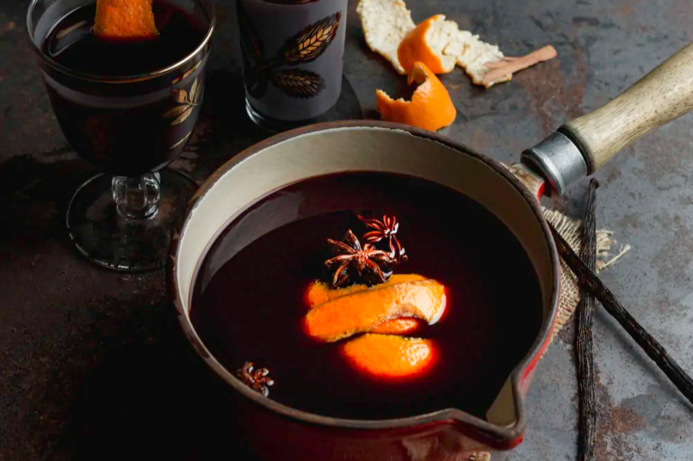 pot of hot mulled chai topped with citrus peel