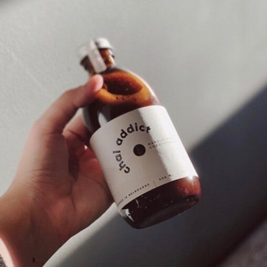 hand holding 300ml bottle of chai addict