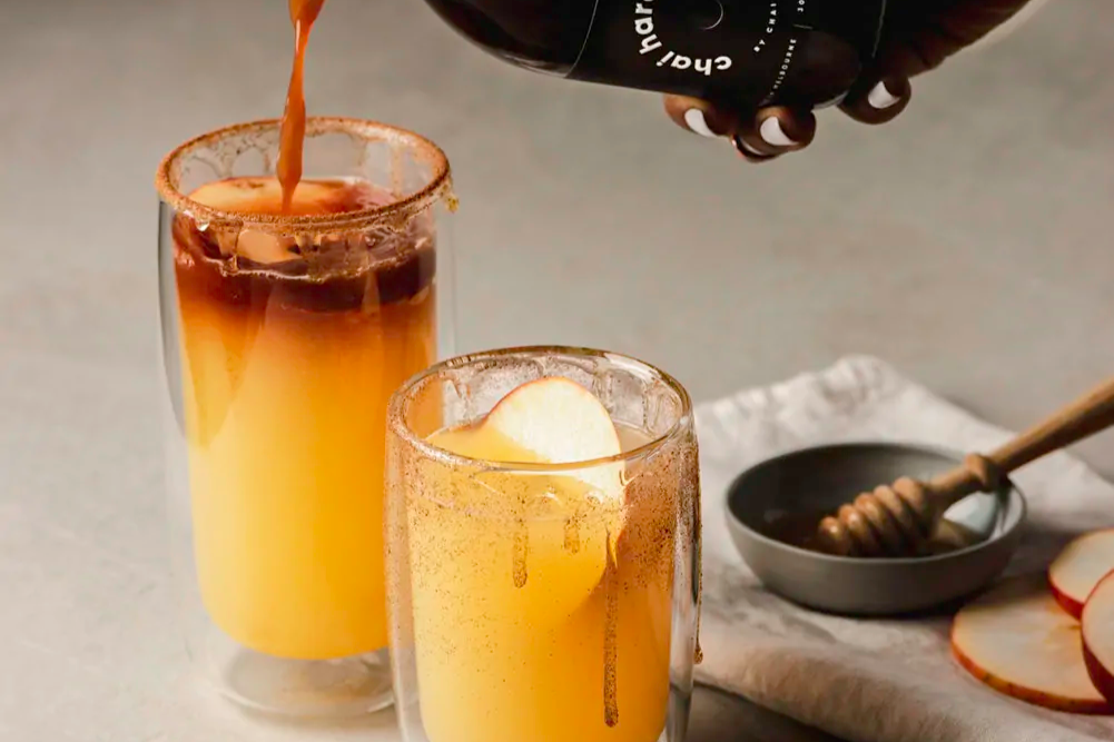two glasses of refreshing chai soda drizzled with honey