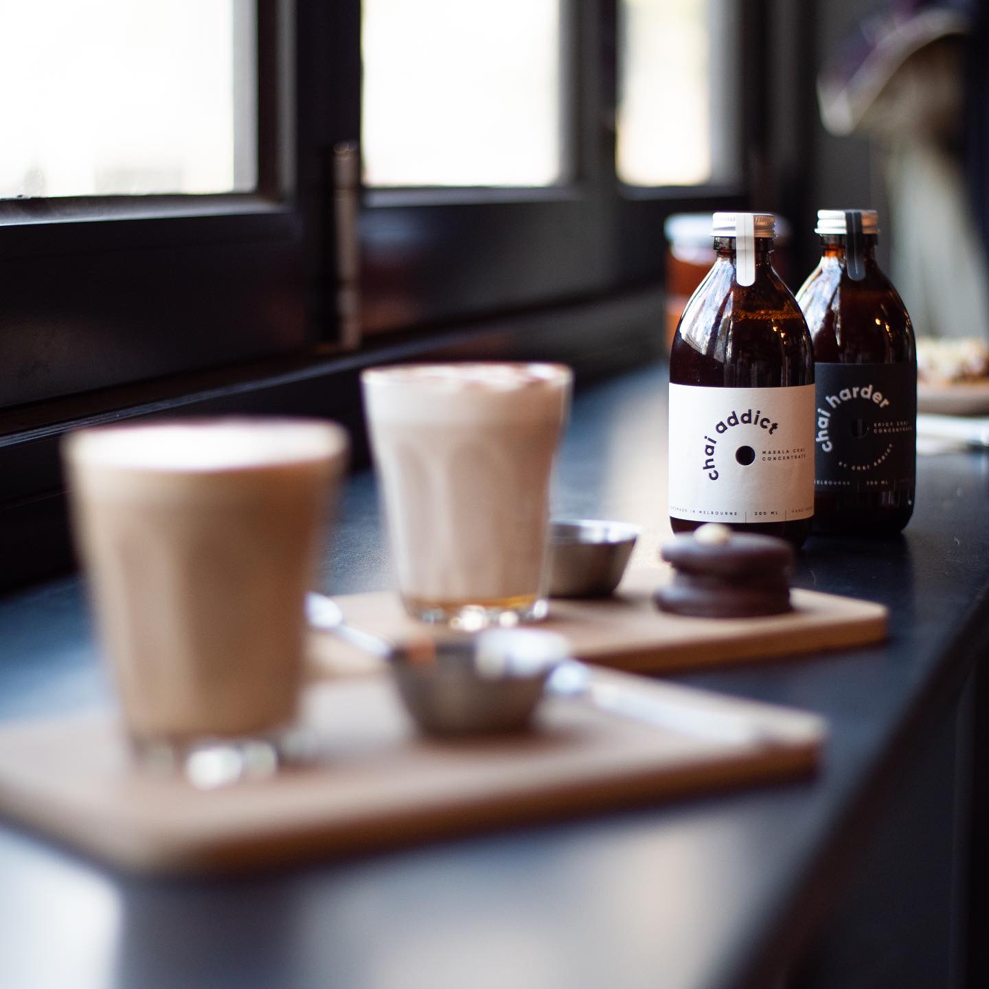 Cups of chai latte brewed served at a cafe accompanying delicious treats, honey and chai latte concentrates