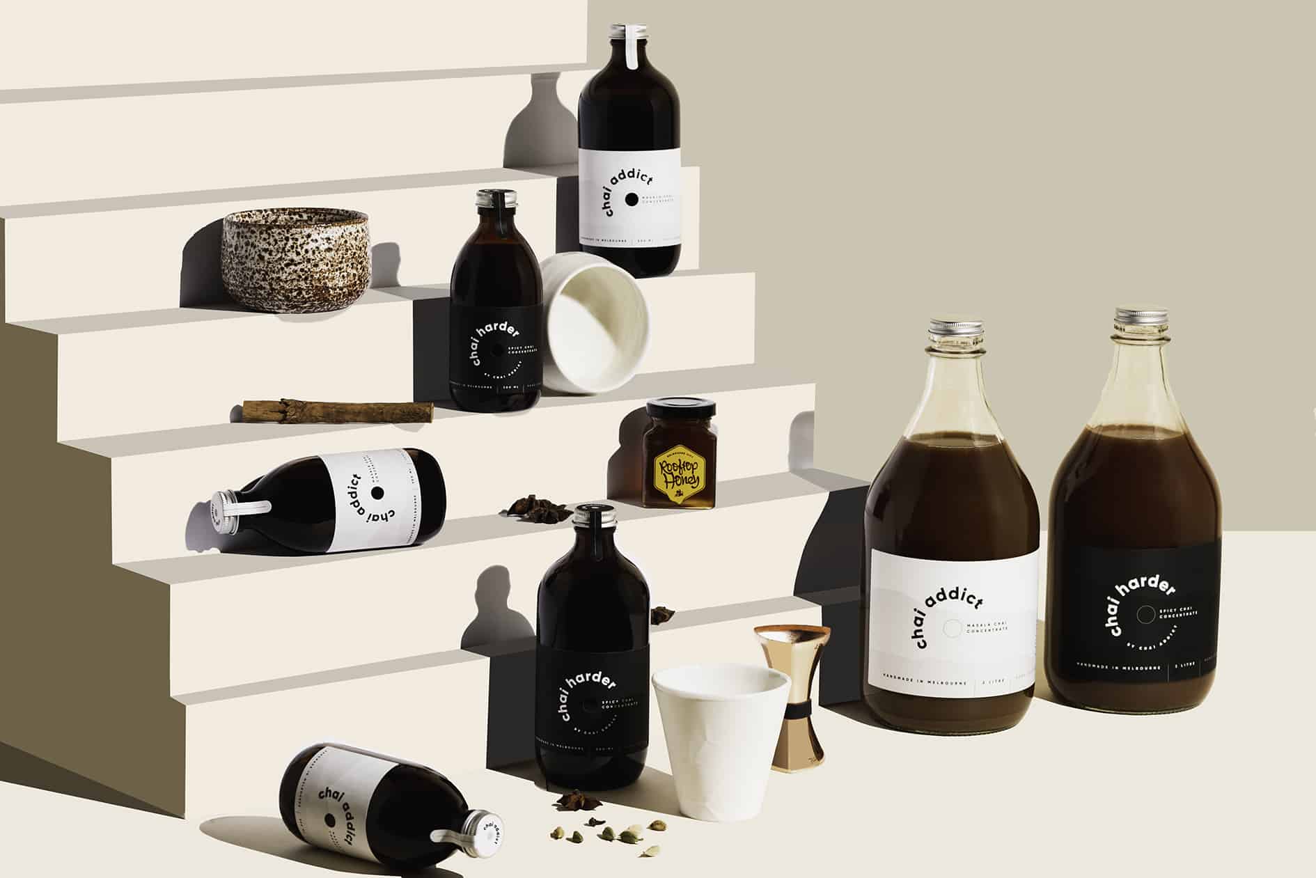 Assorted chai latte concentrate bottles arranged on a step display, offering a delightful variety for chai enthusiasts