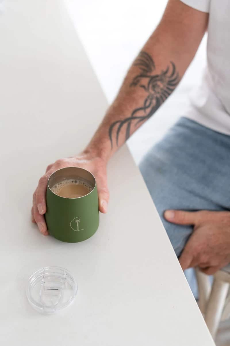 person holding caye life green keep cup