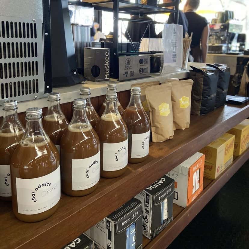 foodservice chai addict bottles displayed on a cafe bench