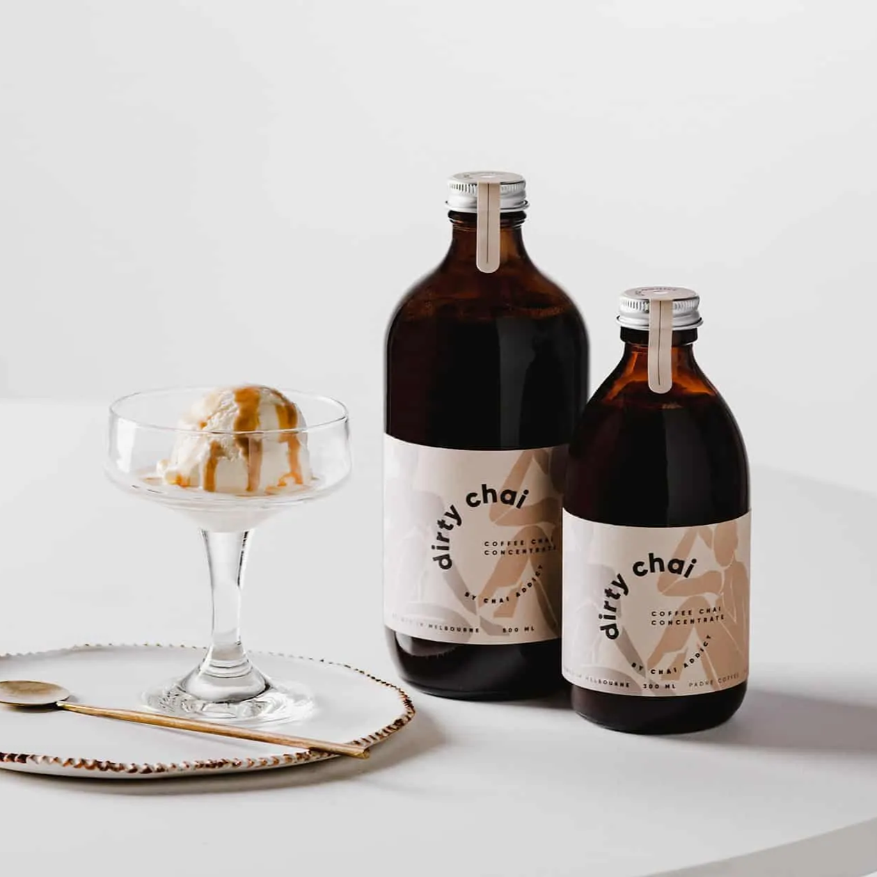 affogato ice cream drizzled with dirty chai concentrate served on a peppered ceramic saucer and gold teaspoon