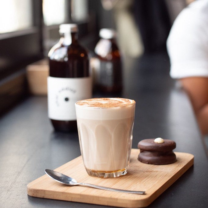 he essence of chai latte captured and served on a small chopping board with a side of alfjores at a cafe